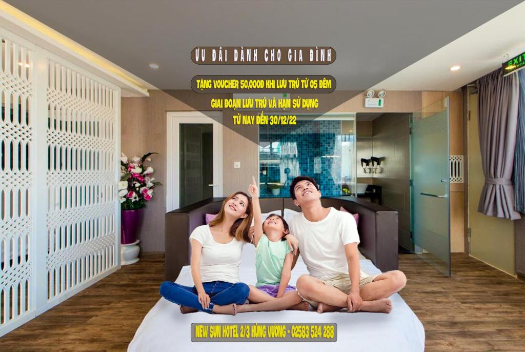 a family sitting on a bed in a room at New Sun Hotel in Nha Trang