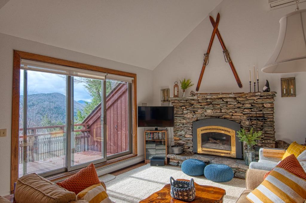 sala de estar con chimenea y ventana grande en Gnome Home Mountain Ski Chalet w/Sauna Killington, en Stockbridge