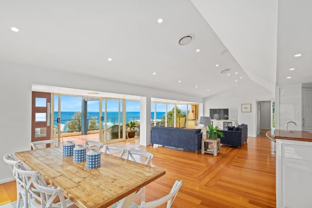 a kitchen and living room with a table and chairs at Spacious Home with Ocean Views, Close to Beach in Wamberal