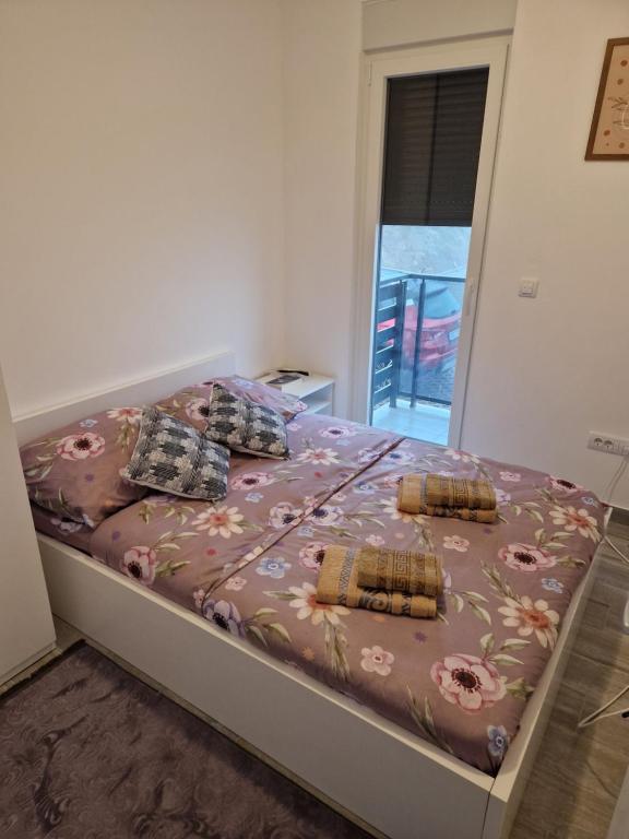 a bedroom with a bed with a floral bedspread and pillows at Diva 2 in Divčibare