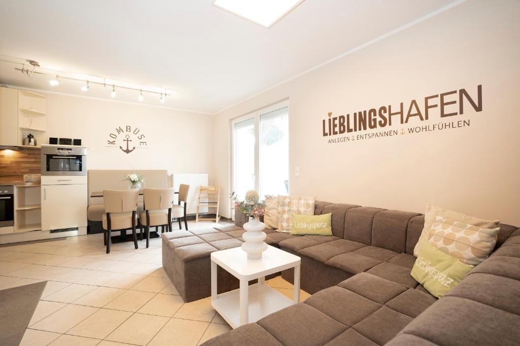 a living room with a couch and a kitchen at Lieblingshafen in Grömitz
