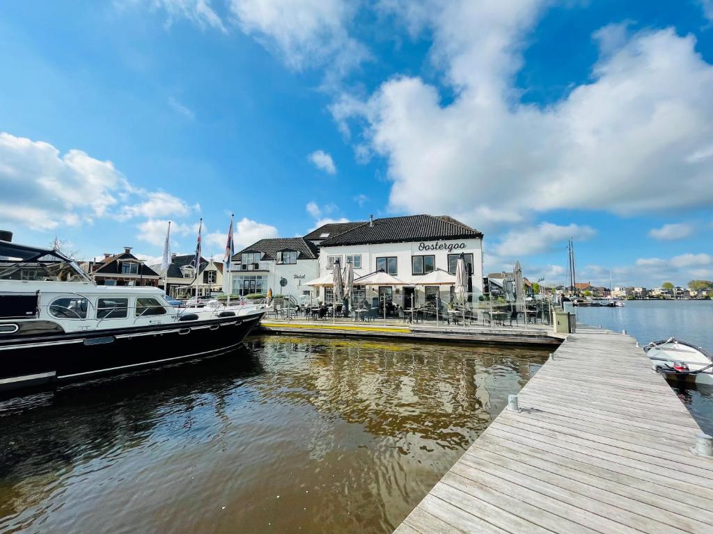 a dock with two boats docked next to a building at Hotel Oostergoo in Grou