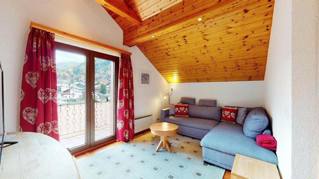 een woonkamer met een bank en een groot raam bij Superb family apartment in centre of the village of Vercorin in Vercorin