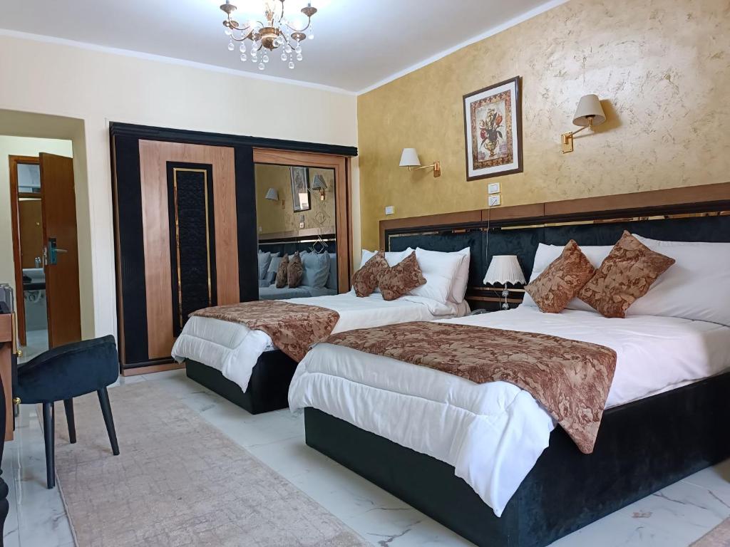 Pokój hotelowy z 2 łóżkami i żyrandolem w obiekcie Indiana Hotel w Kairze