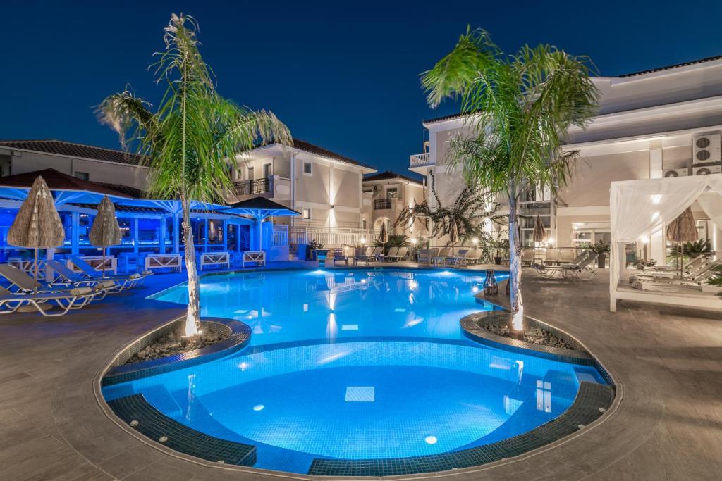 uma piscina com duas palmeiras no meio em Tzante Hotel Zakynthos, Adults Only em Laganas