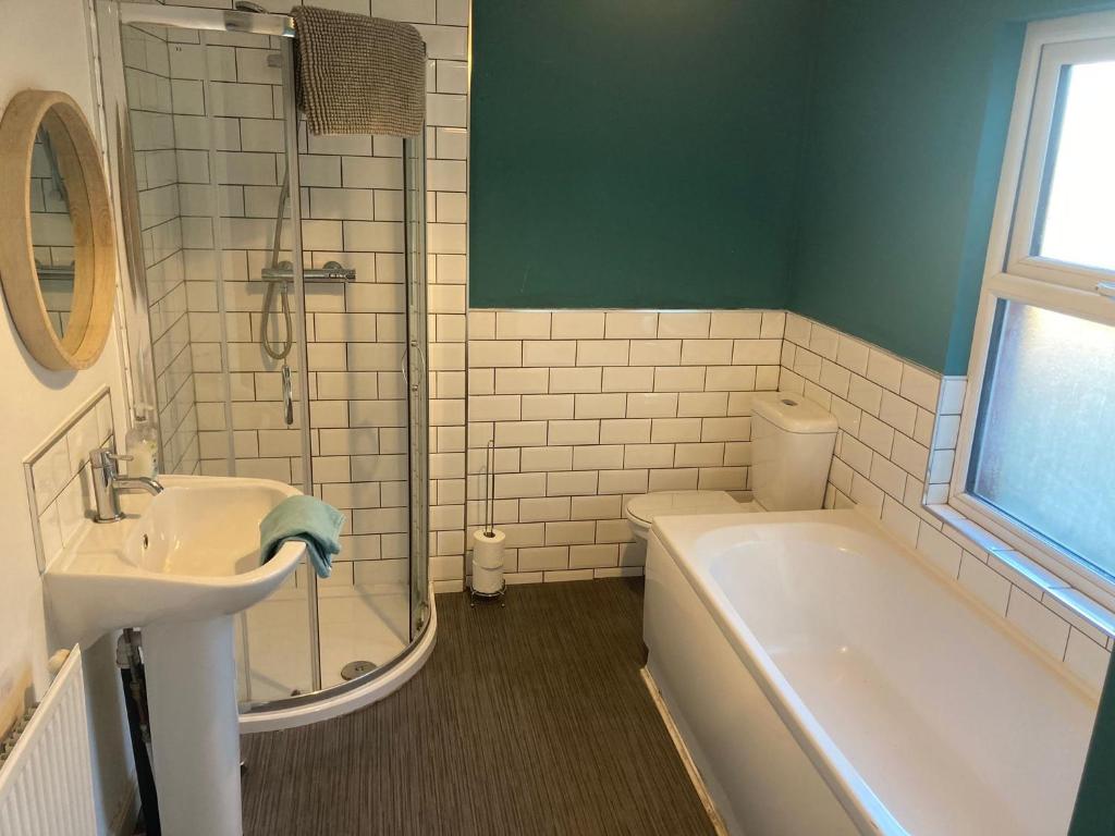 a bathroom with a sink and a tub and a toilet at Jefferson House in Goole