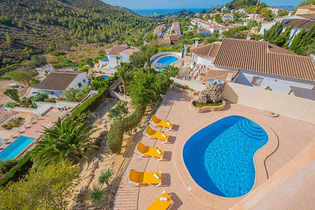 an aerial view of a resort with a swimming pool and chairs at Villa Claudia - PlusHolidays in Benitachell