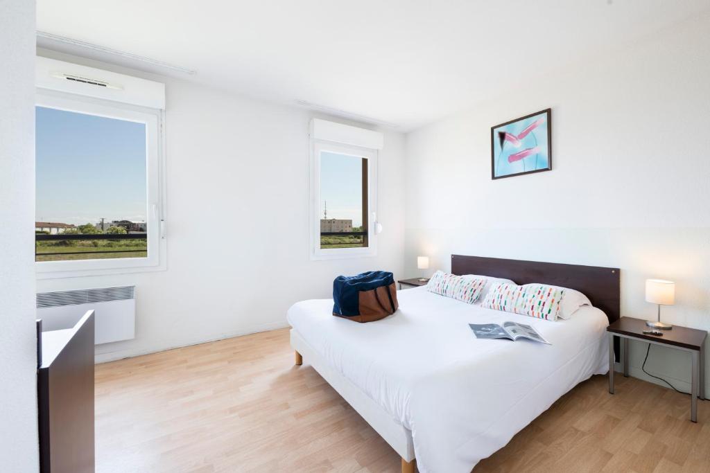 a white bedroom with a bed and two windows at Garden & City Clermont-Ferrand - Gerzat in Gerzat
