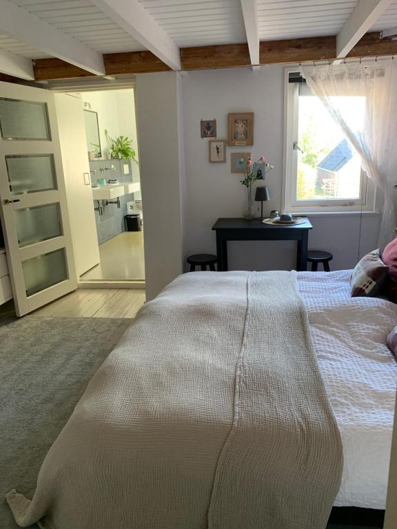 una camera da letto con un letto, una scrivania e una finestra di B&B Vintage Room a Vught