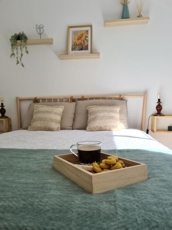 a tray with a cup of coffee on a bed at Canto da Rocha Guesthouse in Almada