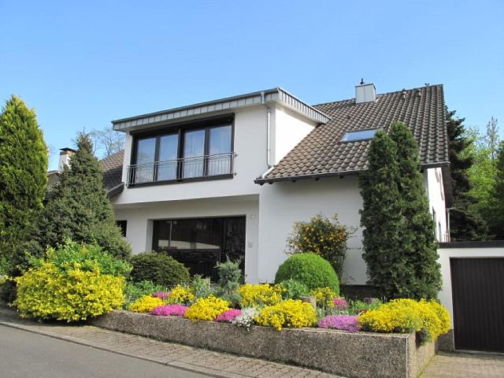 ein weißes Haus mit Blumen im Vorgarten in der Unterkunft Haus Anna in Beaumarais