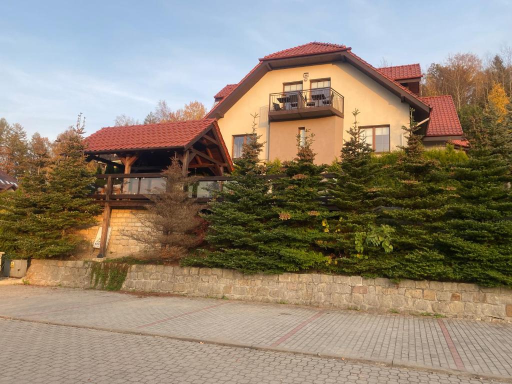 a house on a stone wall with trees at Emilio in Kudowa-Zdrój