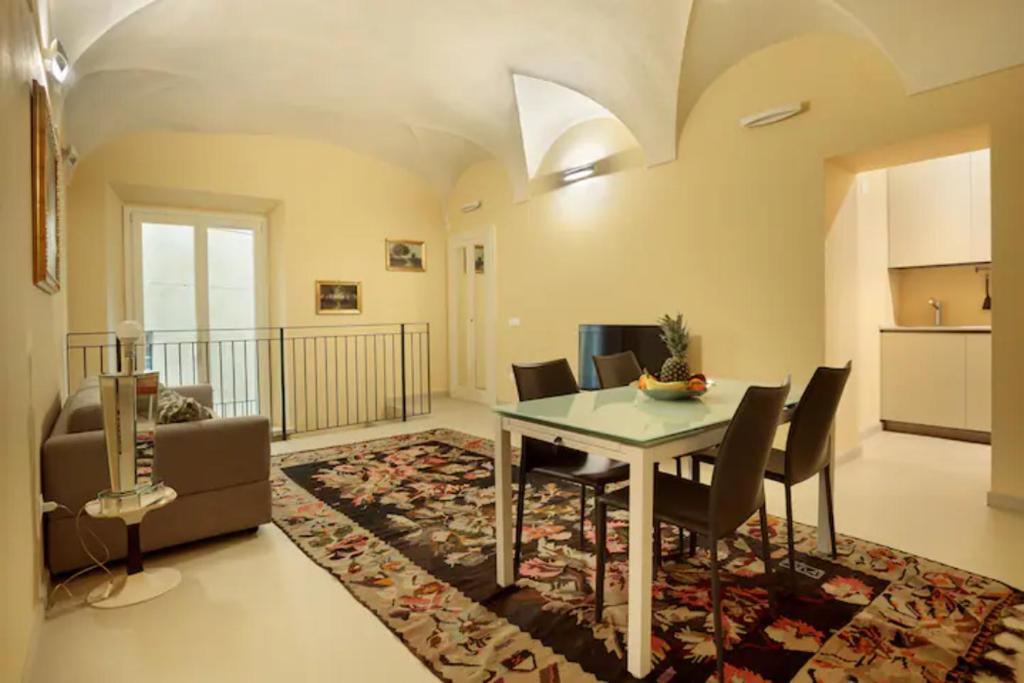 een woonkamer met een tafel en stoelen en een keuken bij CHARMING APARTMENT IN PARMA/ TEATRO REGIO / WIFI in Parma