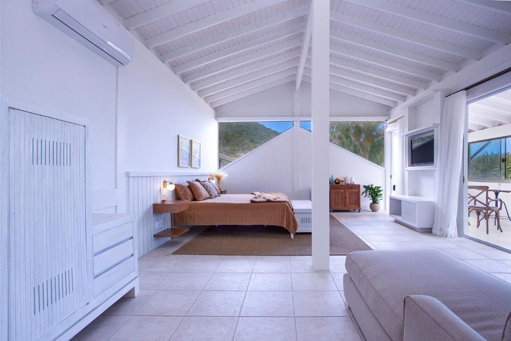 1 dormitorio con 1 cama en una habitación blanca en Casa Hotel Sahy en Barra do Sahy