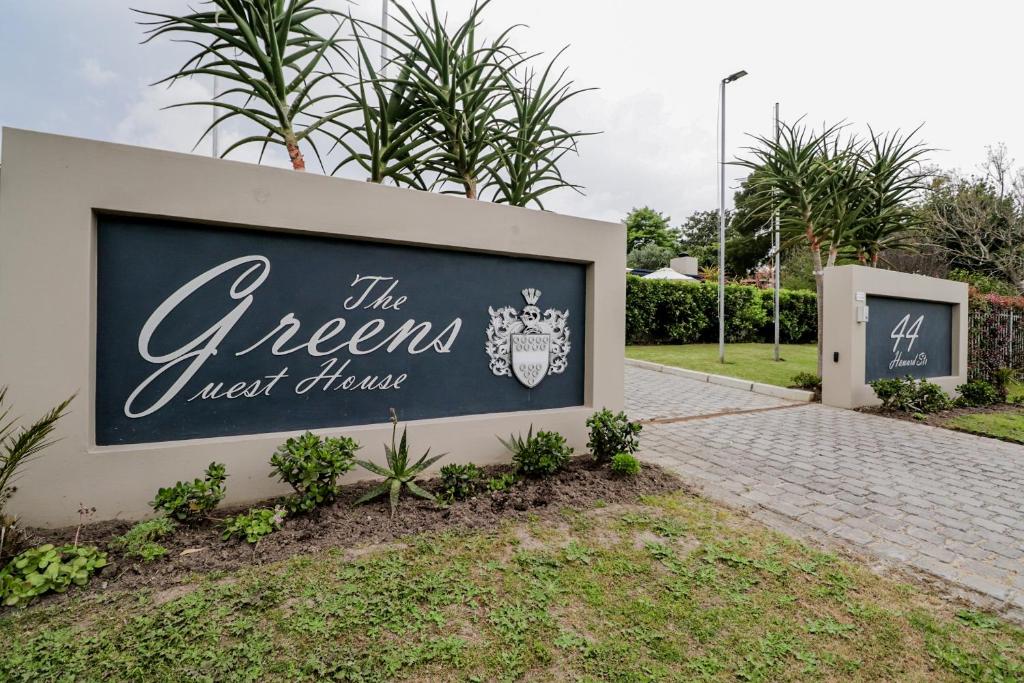a sign that reads the greens next to a sidewalk at The Greens Guest House in Knysna