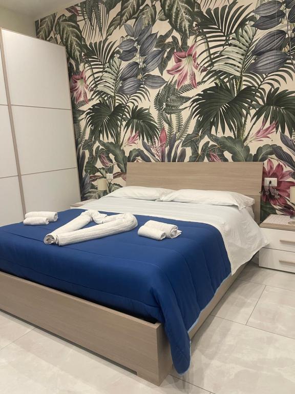 sypialnia z łóżkiem z ręcznikami w obiekcie Nase e cane home Napoli w mieście Napoli