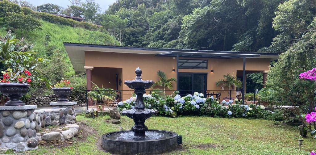 une maison avec une fontaine en face d'un jardin dans l'établissement Finca Caramelo, à Boquete