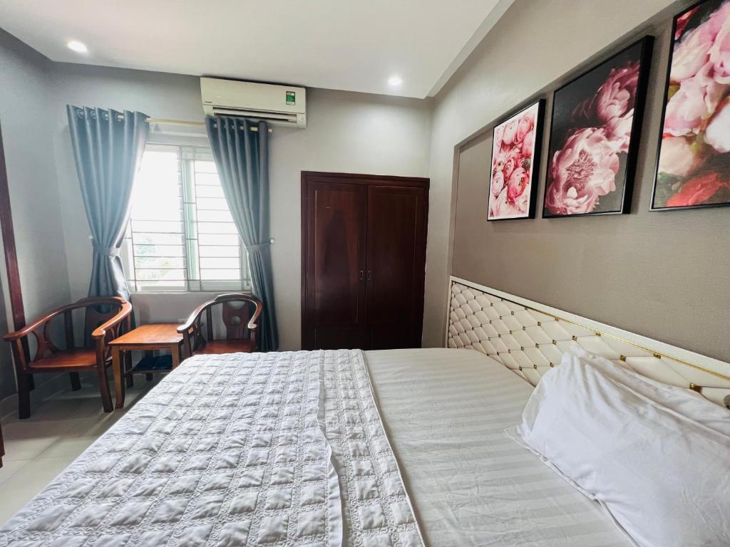 a bedroom with a bed and a table and a window at Hoang Ngan 1 Hotel - TP. Vinh in Vinh