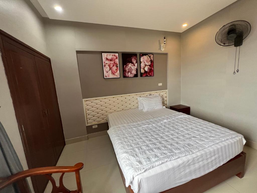 a bedroom with a bed and two pictures on the wall at Hoang Ngan 1 Hotel - TP. Vinh in Vinh