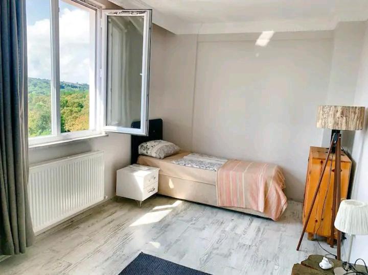 um quarto com uma cama e uma grande janela em forest villa-2, 5 minutes from Istanbul airport em Taşoluk