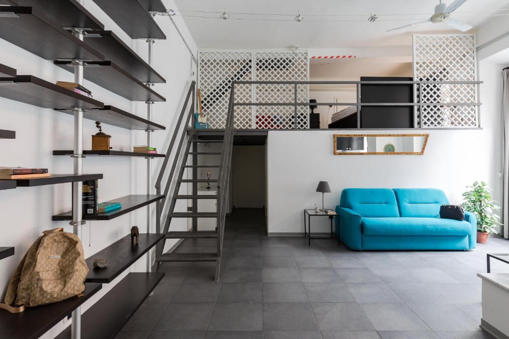 a living room with a staircase and a blue couch at Trevi Fountain Loft Apartments in Rome