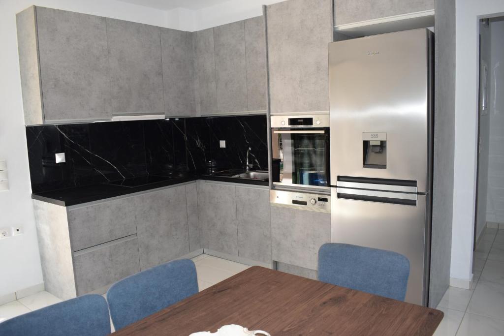 a kitchen with a dining table and a refrigerator at Black & White Apartments in Bekatoráta