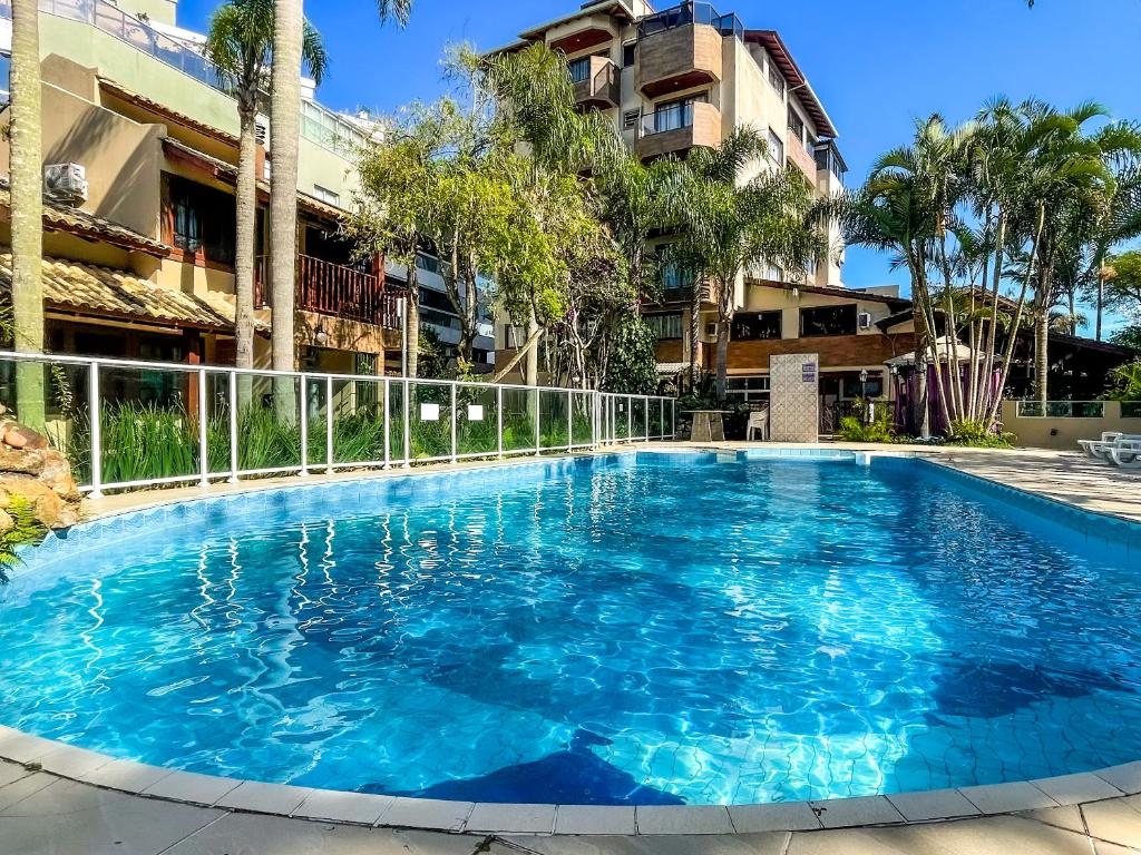 uma grande piscina azul em frente a um edifício em Hotel & Pousada Sonho Meu em Florianópolis