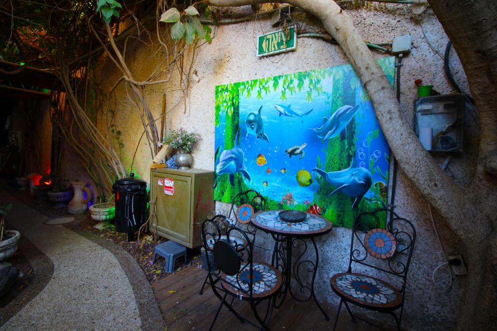 a table and chairs in a room with a painting on the wall at Sunset Inn in Eilat