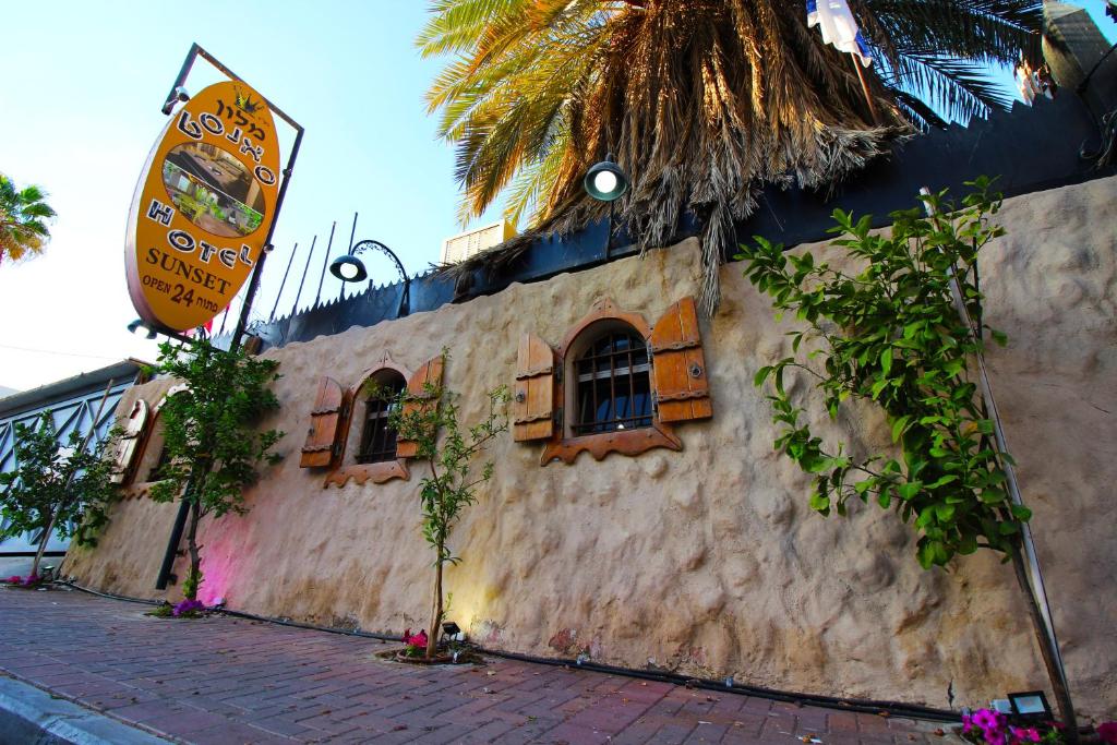 a building with windows and a sign on it at Sunset Inn in Eilat