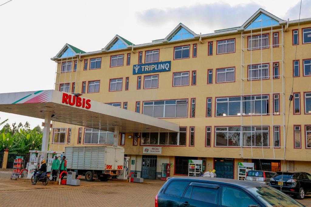 un grande edificio giallo con un cartello di incisione di TRIPLINQ HOTEL & RESORT Meru a Nkubu