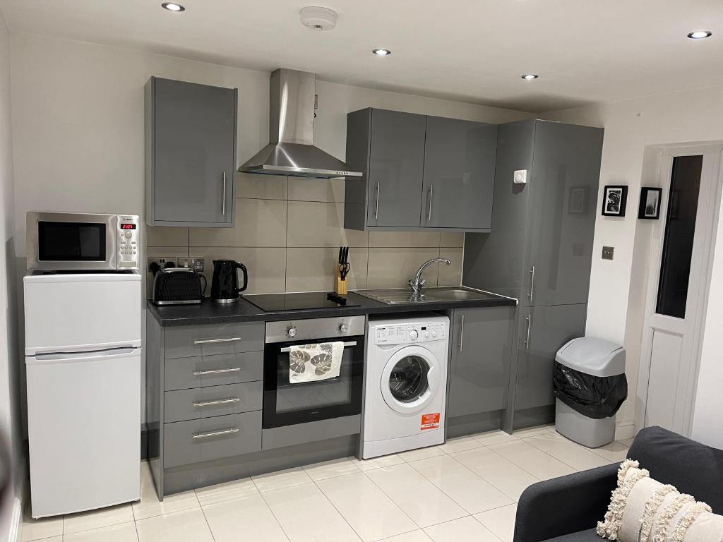 uma cozinha com um frigorífico e uma máquina de lavar e secar roupa em Modern 1 Bedroom Holiday Apartment in Southminster em Southminster