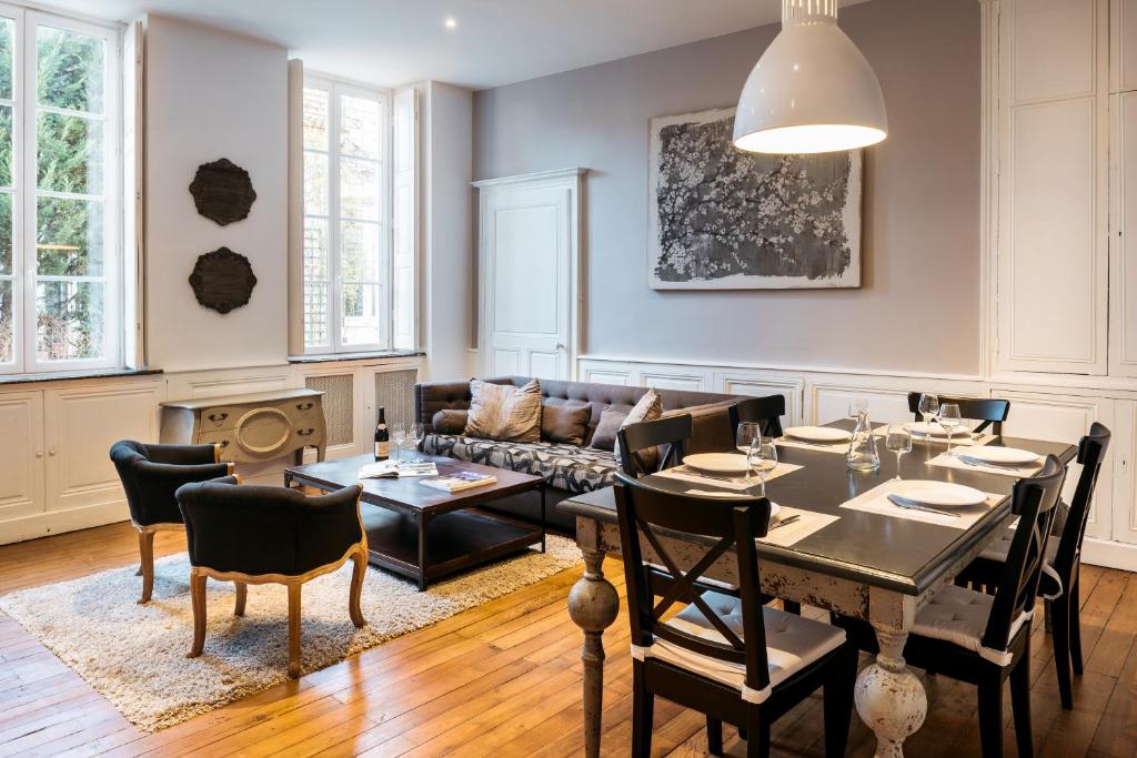 a living room with a table and a couch at La Maison des Courtines in Beaune