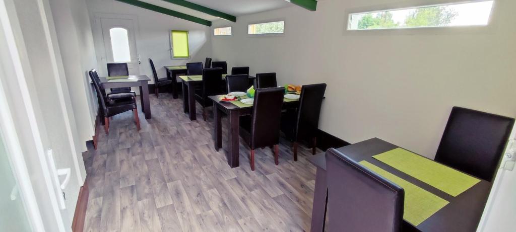 jadalnia z czarnymi stołami i czarnymi krzesłami w obiekcie Gyepszél Panzió Tokaj w Tokaju