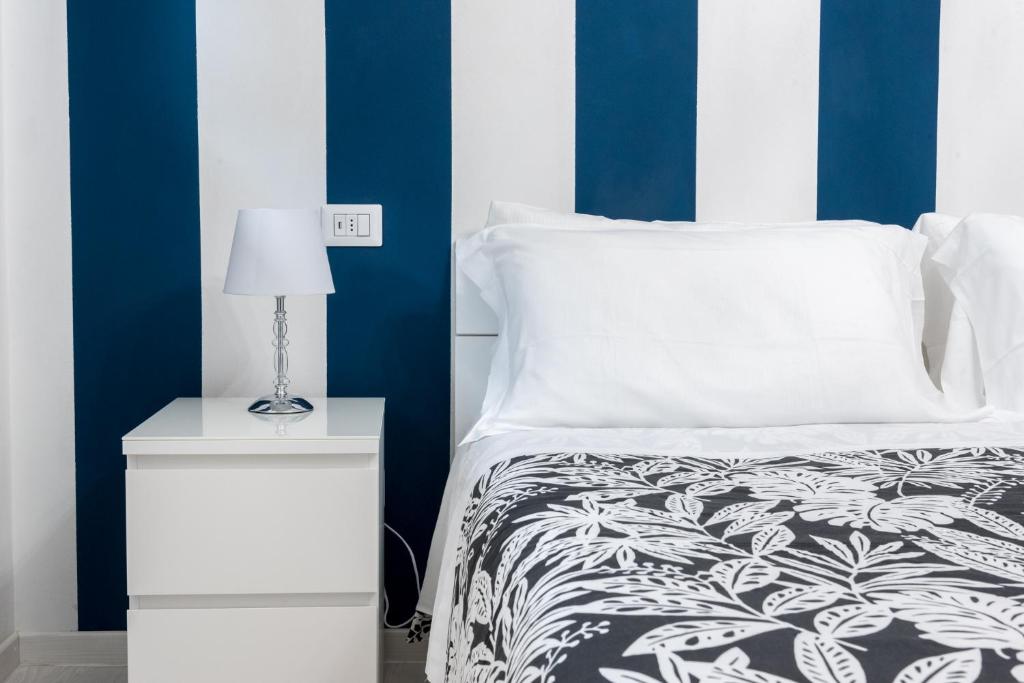ポルト・サンテルピーディオにあるResilienza Tropical Apartments & Roomのベッドルーム1室(ベッド1台、ナイトスタンド、ランプ付)