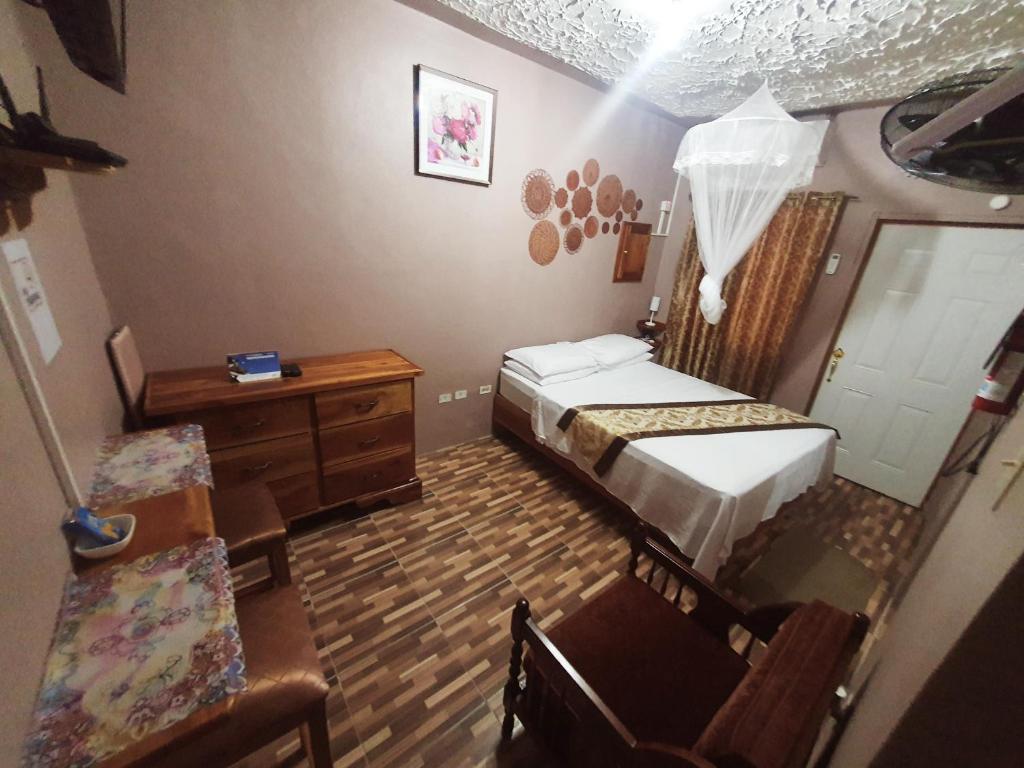 Mesmerize Guest House في بورت أنطونيو: غرفة نوم صغيرة بسريرين وخزانة