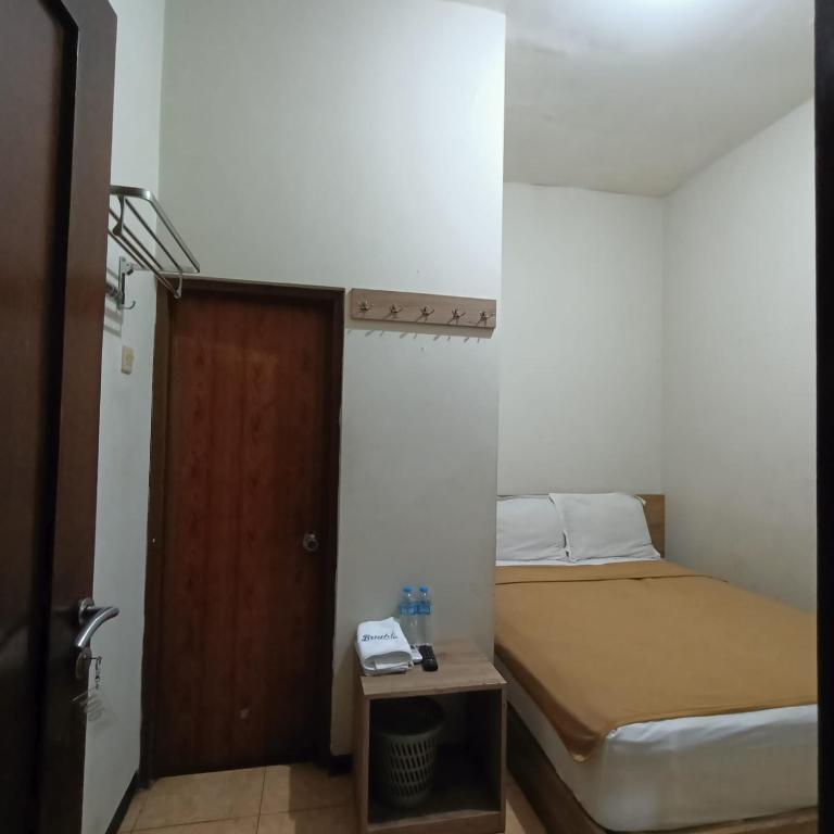 a small bedroom with a bed and a door at NamRoom at Tangki Lio in Jakarta
