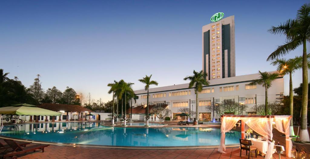 a hotel with a swimming pool in front of a building at Nam Cuong Hai Duong Hotel in Hải Dương