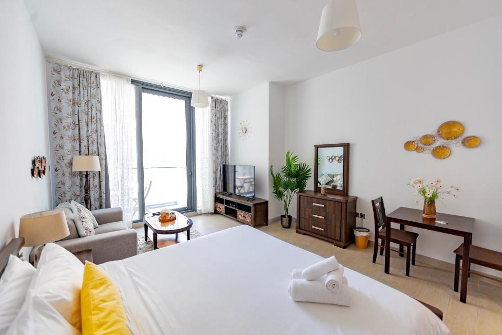 ein Schlafzimmer mit einem Bett und ein Wohnzimmer in der Unterkunft Liv Residence in Dubai