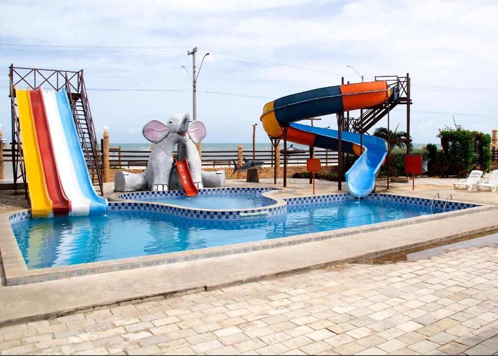 Un tobogán de agua con un elefante en una piscina en Hotel Costa Atlantico en Areia Branca