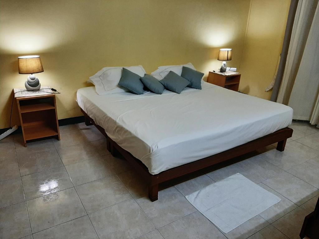 a bedroom with a large bed with blue pillows at DINO 1 in Trou aux Biches