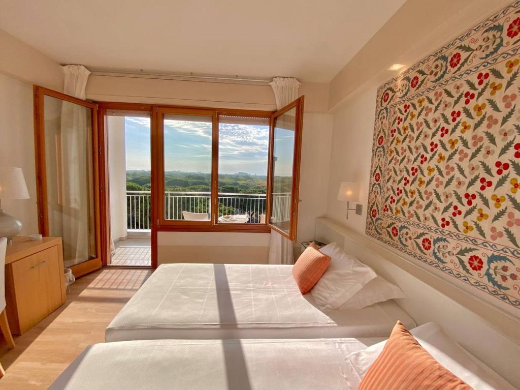 una camera con due letti e una grande finestra di Art&Park Hotel Union Lido a Cavallino-Treporti