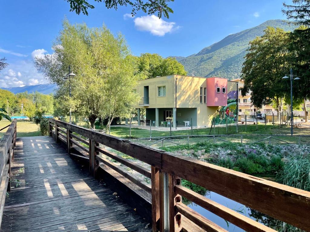 a wooden bridge over a river with a house at Ostello Fiume Tirino in Bussi sul Tirino