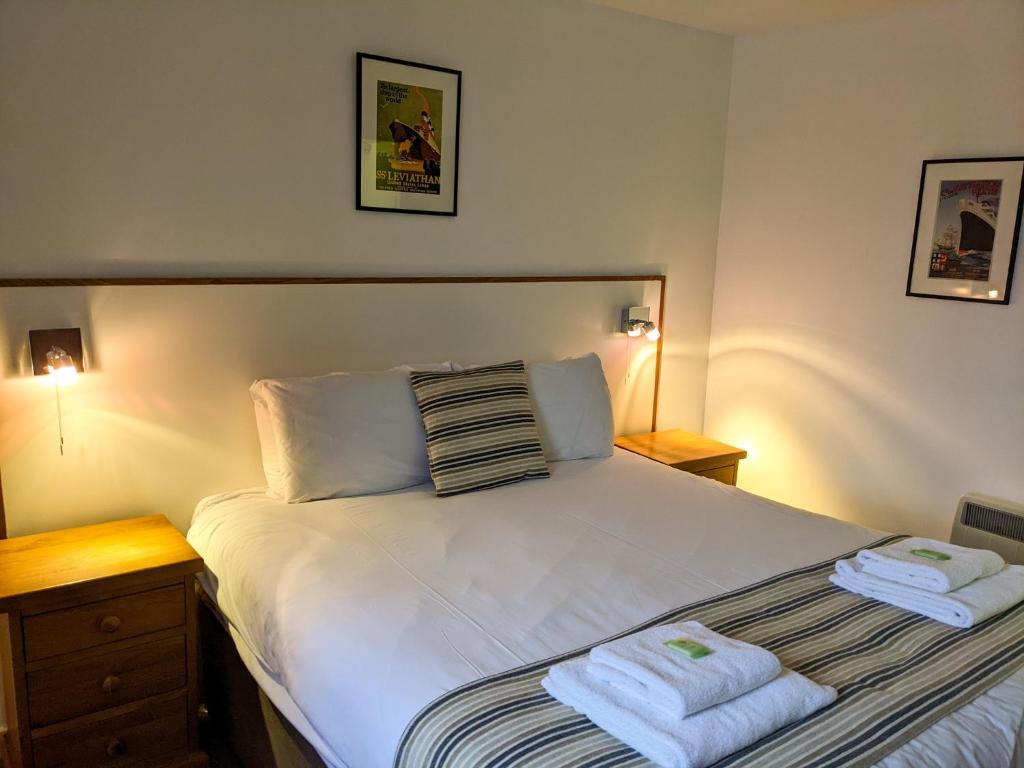 1 dormitorio con 1 cama con 2 toallas en Ferry Inn, en Stromness