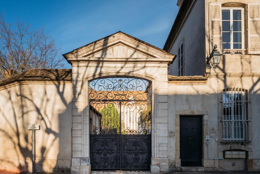 um portão para um edifício com uma porta grande em La Maison des Courtines em Beaune