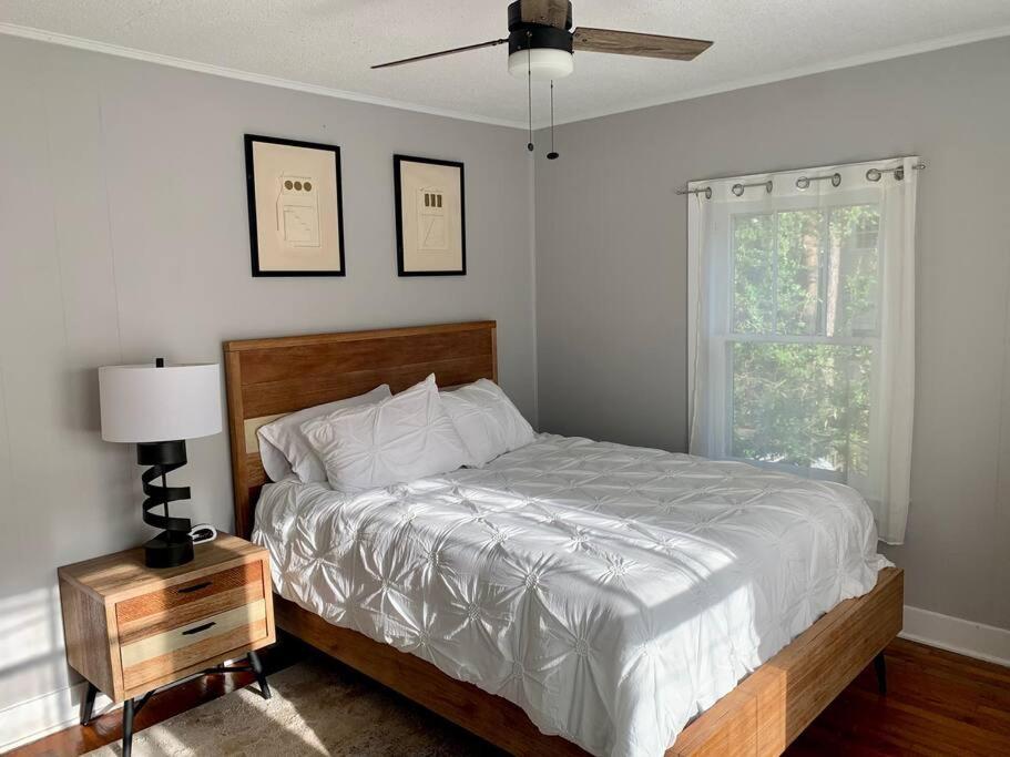a bedroom with a bed and a window with a fan at Spanish Town / Downtown Apartment in Baton Rouge