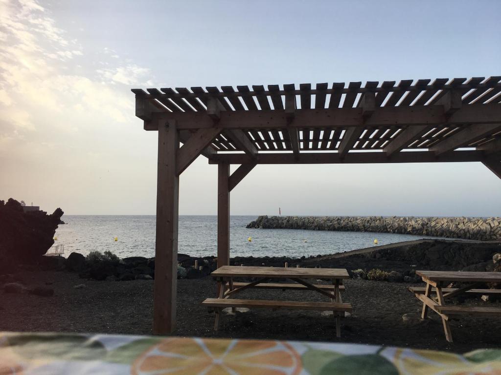 two picnic tables on the beach near the water at Apto Tagoro, La Restinga in La Restinga