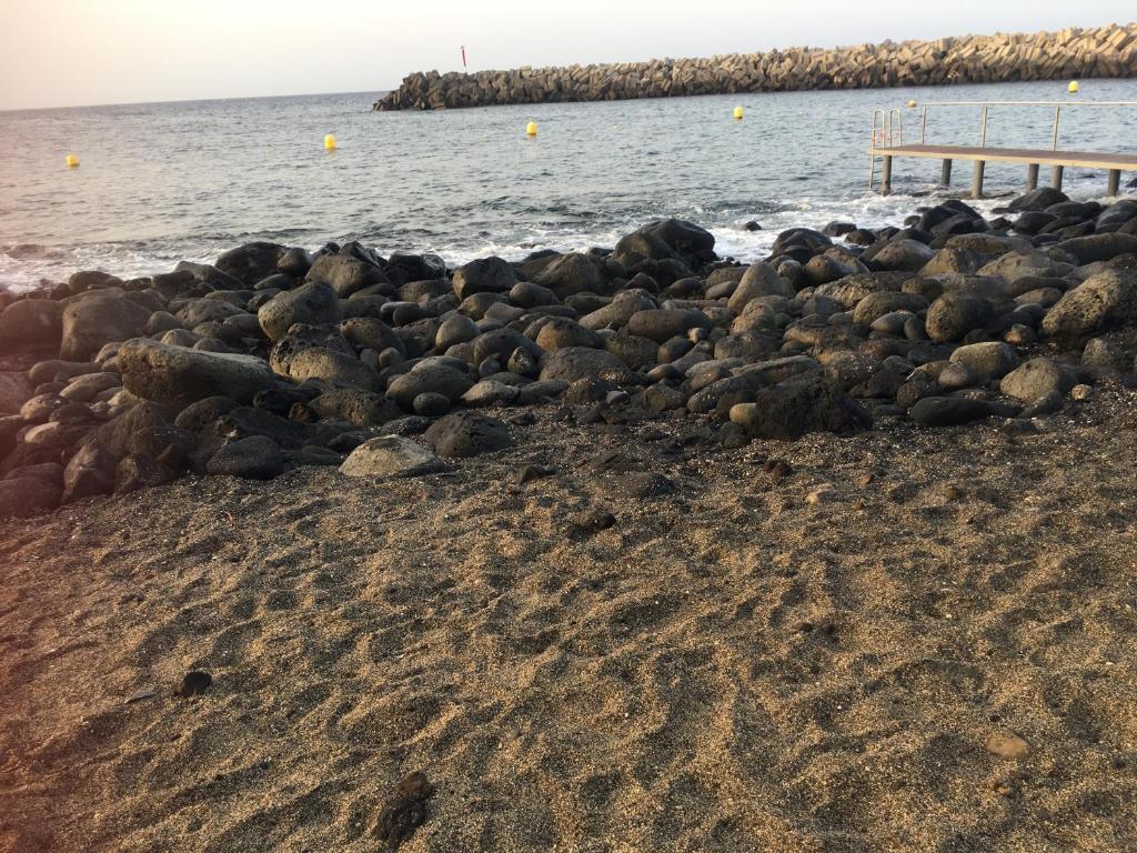 a pile of rocks on a beach next to the water at Apto Tagoro, La Restinga in La Restinga