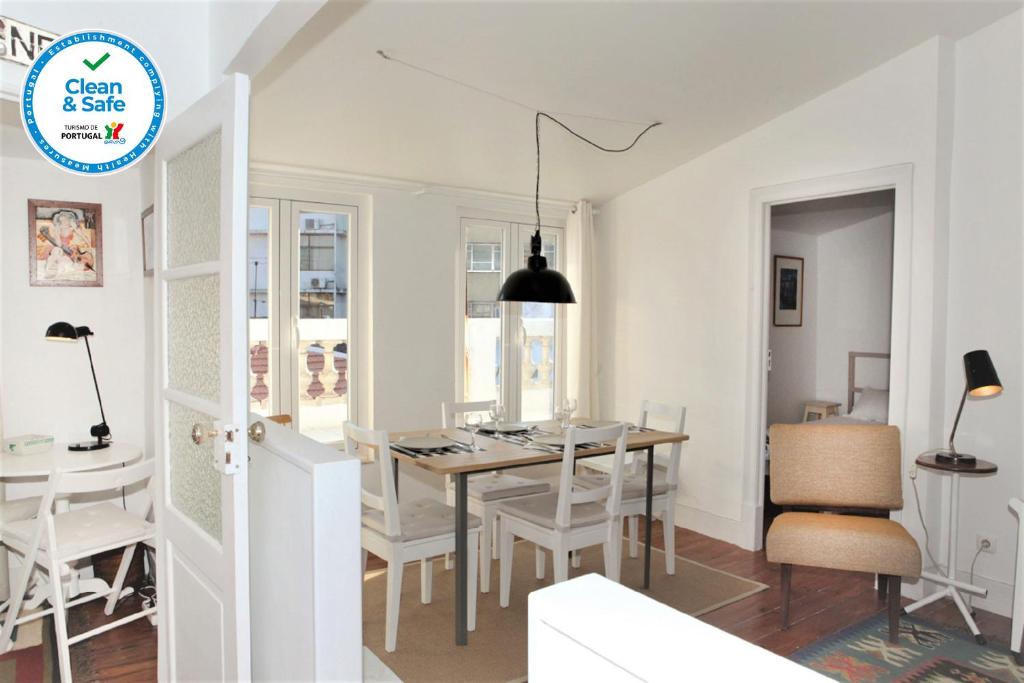 a kitchen and dining room with a table and chairs at Alegria Apartment in Principe Real in Lisbon