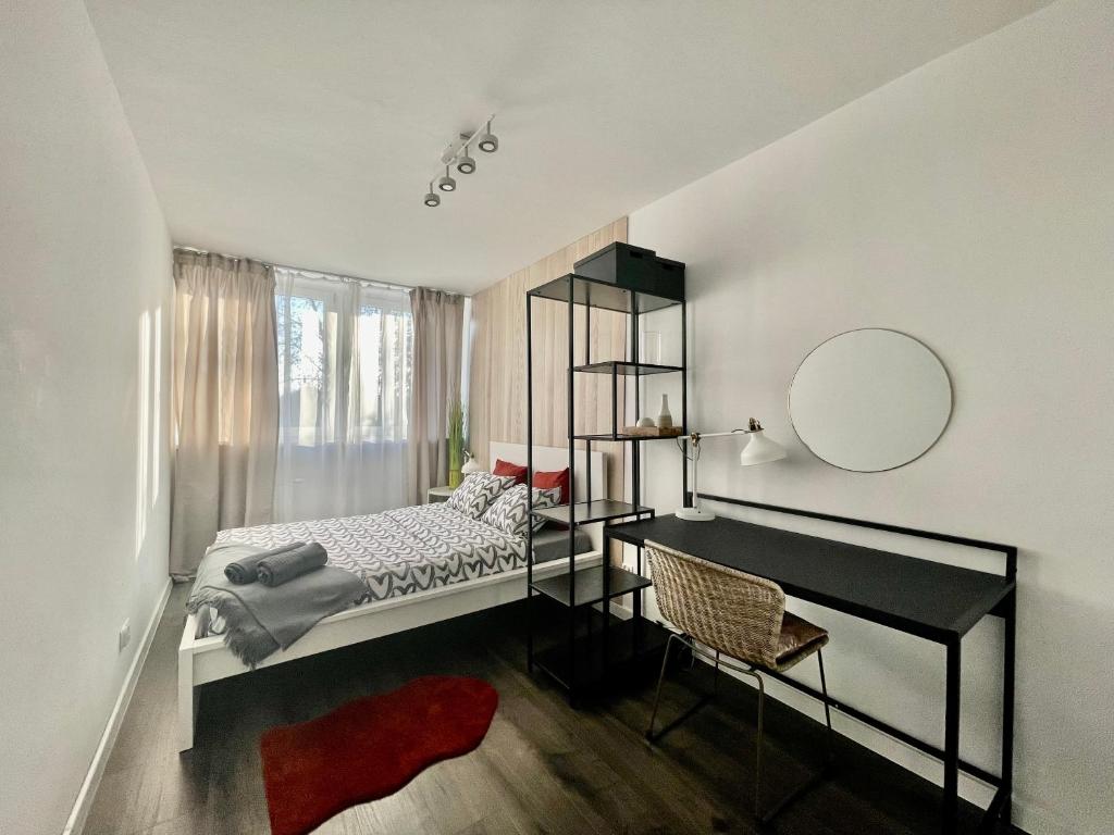 a bedroom with a bed and a desk and a mirror at Cozy Apart - Self check-in 24h in Wrocław