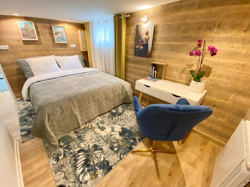 a bedroom with a bed and a blue chair at Appartament Bel Air in Cherbourg en Cotentin